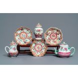 A Chinese famille rose relief-decorated teapot, milk jug and tea caddy on stands, Yongzheng