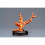 A Chinese carved red coral group of a lady among blossoming branches, 19th C.