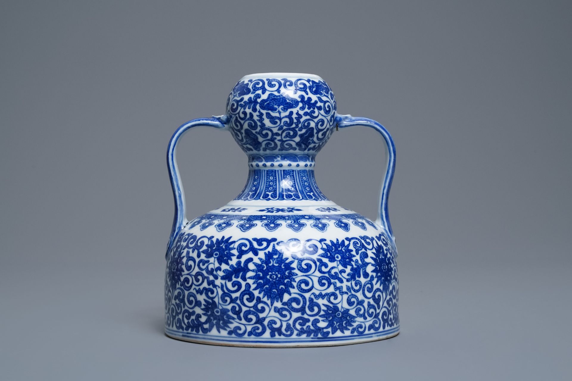 A Chinese blue and white two- Handled 'lotus scroll' jug, Qianlong mark, 19/20th C.