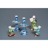 A pair of Chinese blue and white candlesticks and three famille rose figures of boys, 19th C.