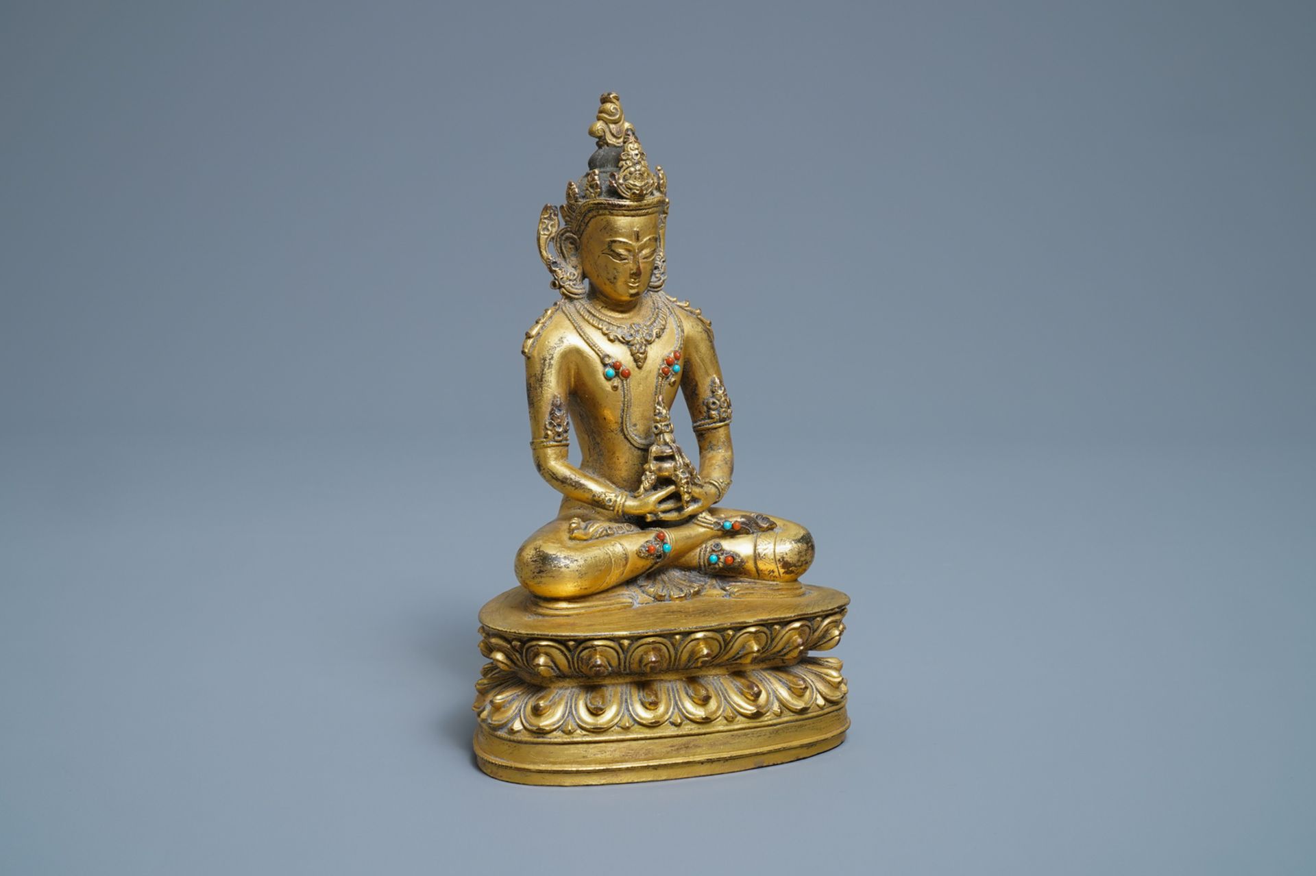 A Chinese coral- and turquoise-inlaid gilt bronze figure of Buddha Amitayus, 18/19th C.