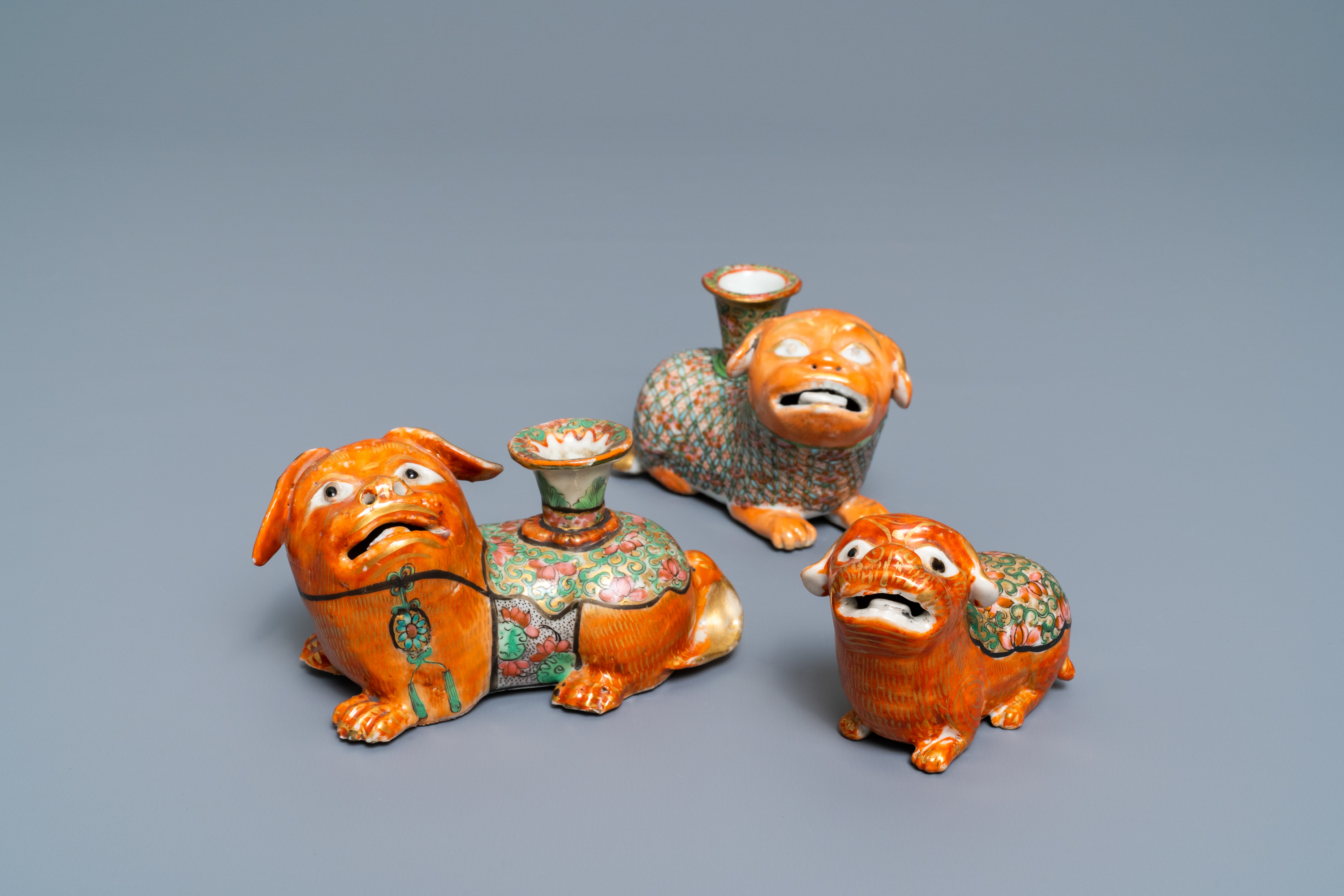 Three Chinese Canton famille rose models of dogs, two with candle holders, 19th C.