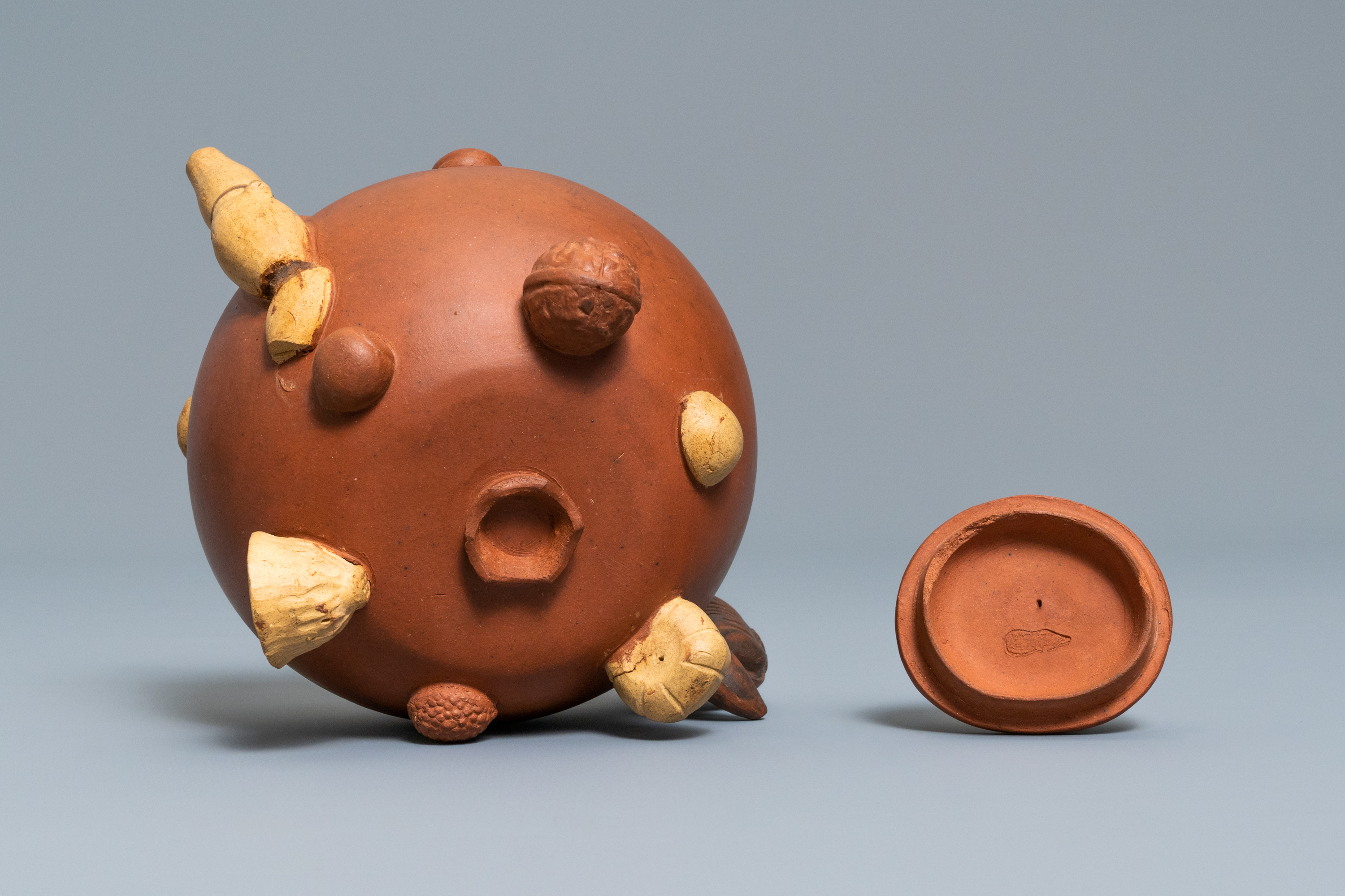 A Chinese Yixing stoneware relief-decorated teapot with nuts and fruits, impressed mark, 19th C. - Image 8 of 8