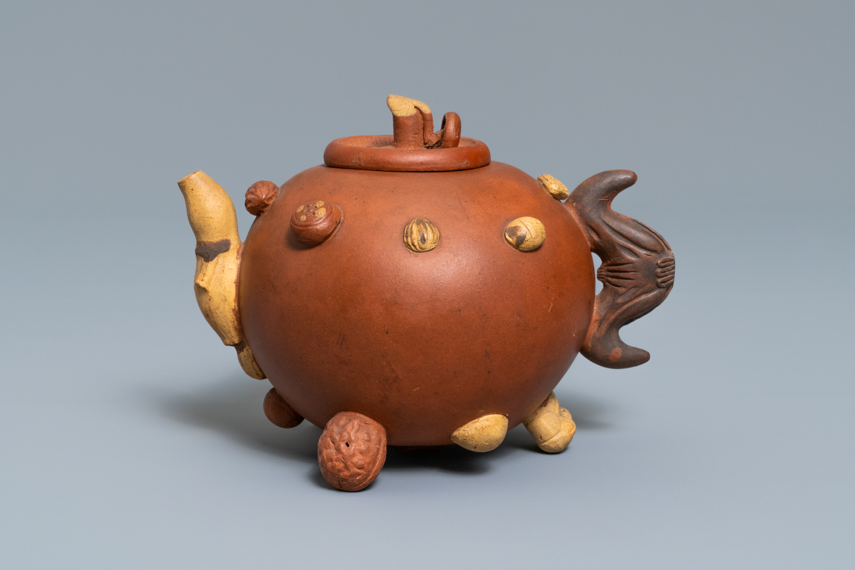 A Chinese Yixing stoneware relief-decorated teapot with nuts and fruits, impressed mark, 19th C. - Image 3 of 8