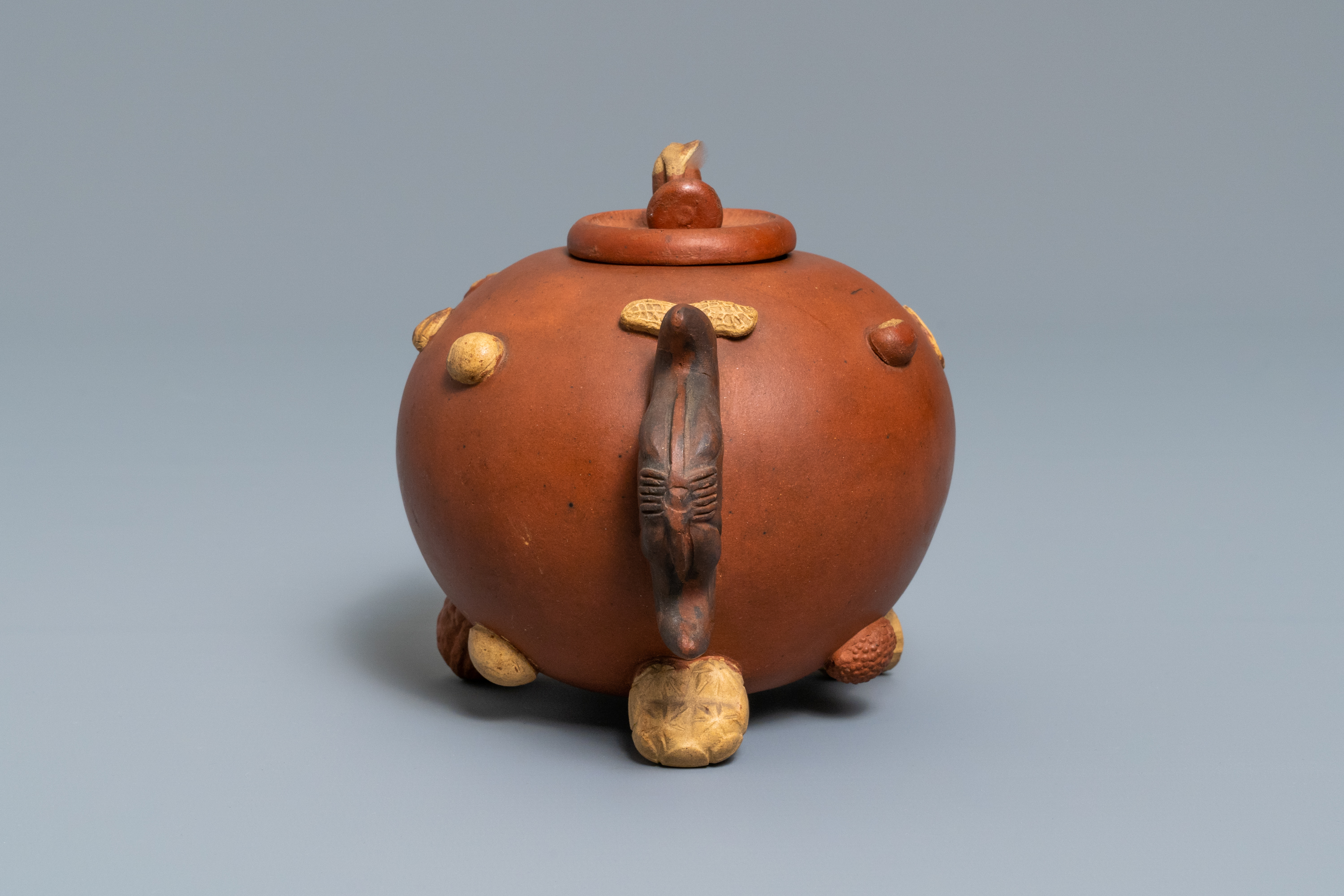 A Chinese Yixing stoneware relief-decorated teapot with nuts and fruits, impressed mark, 19th C. - Image 4 of 8