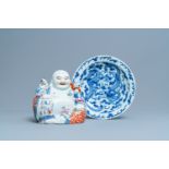 A Chinese blue and white 'dragon' dish and a famille rose figure of Buddha, 19th C.