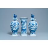 A Dutch Delft blue and white three-piece vase garniture with a dog, 18th C.