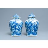 A pair of Chinese blue and white baluster vases and covers with birds in a rocky setting, Kangxi