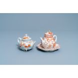 Two Chinese iron red and gilt relief-decorated teapots and one stand, Kangxi/Yongzheng