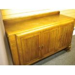 1930S OAK THREE DOOR RAILBACK SIDEBOARD with central interior drawers on bulbous supports, 99cms