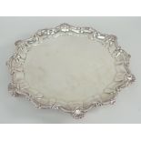 EDWARD VII SILVER SALVER having shell and scroll border, raised on three ball and claw feet,