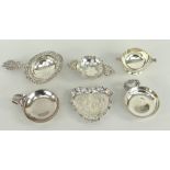 SIX SMALL SILVER COLLECTABLES comprising three wine tasters, a tea strainer, a miniature quaich