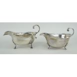 TWO SIMILAR SILVER SAUCE BOATS raised on three feet with scroll handles, Chester and London