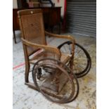 VINTAGE 'MONK & CO. OF BATH' BATH-CHAIR with twin wheels, with cane-work seat and back, bears