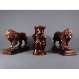 VICTORIAN TREACLE GLAZE STANDING LIONS, a pair, modelled as opposing figures standing with a paw