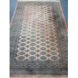 EASTERN WOOLLEN CARPET - red ground with repeating central block pattern and multiple bordered edge,