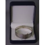 SILVER BANGLE with hinge opening and diamond cut pattern, London 1966, 1.1 troy ozs, 36grms (boxed)