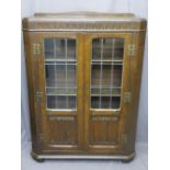 VINTAGE OAK BOOKCASE CABINET having leaded glass doors with linenfold carved lower detail, 124cms H,