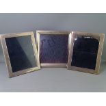 THREE MODERN SILVER PHOTOGRAPH FRAMES, 24.5 x 24.5cms single and 24.25 x 19.25cms pair, all with