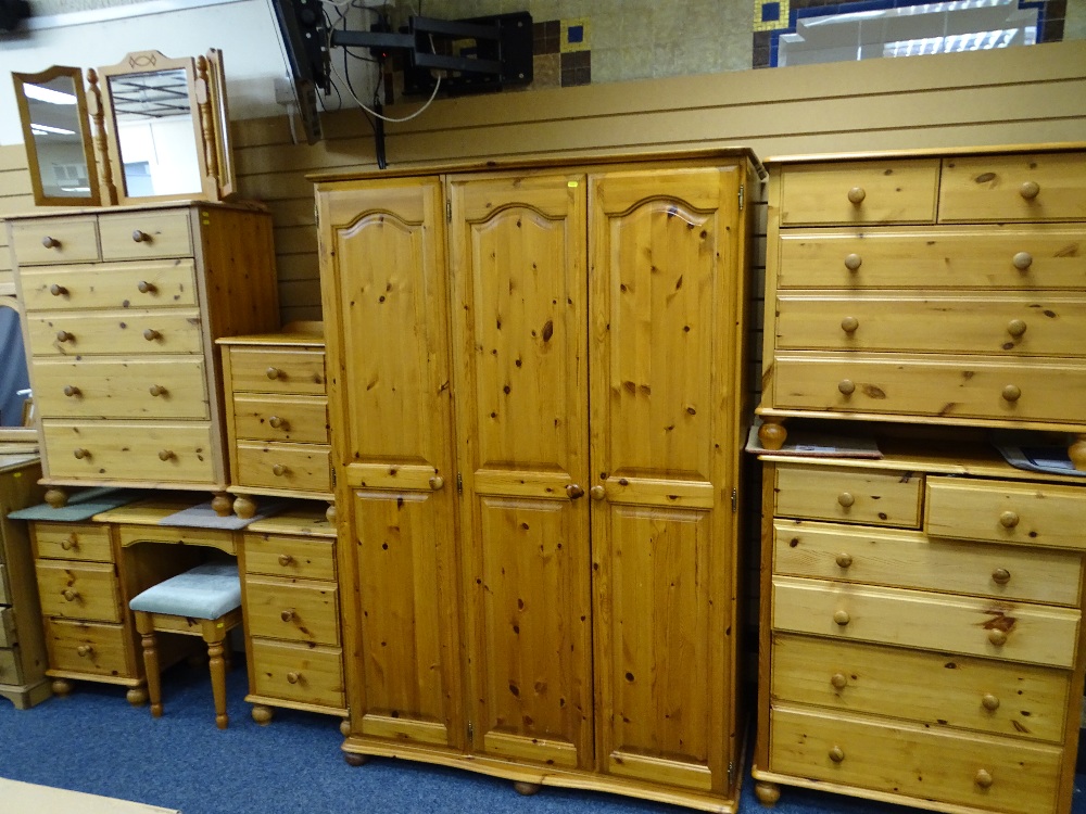 EIGHT PIECES OF MODERN PINE BEDROOM FURNITURE including a three door wardrobe, pedestal dressing