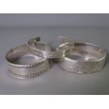 THREE SILVER BANGLES to include a 1906 Edwardian with rope edging and a 1975 hinged bangle, 2.2 troy