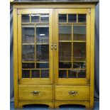 OAK ARTS & CRAFTS BOOKCASE having twin eight panel upper glazed doors with interior adjustable