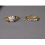 TWO EIGHTEEN CARAT GOLD DIAMOND SET DRESS RINGS including a five stone example in a trough