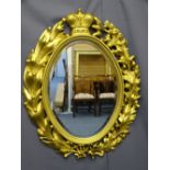 CARVED BLACK FOREST OVAL WALL MIRROR, late 19th Century, gilded with lily of the valley, oak and