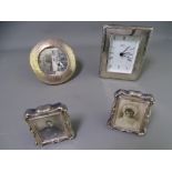 THREE SILVER PHOTOGRAPH FRAMES and a modern clock stamped 925, the 11cms D circular frame,