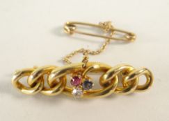 15CT GOLD BAR BROOCH OF GRADUATED CURB LINK DESIGN set with sapphire, diamond and ruby, 4.8 grams.