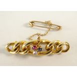 15CT GOLD BAR BROOCH OF GRADUATED CURB LINK DESIGN set with sapphire, diamond and ruby, 4.8 grams.