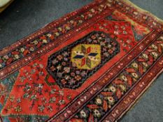 CAUCASIAN NARROW RUG with hexagonal medallion to red field, floral spandrels, serrated leaf border