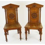 PAIR OF ARCHITECTURAL HALL CHAIRS mid Victorian, having carved cypher medallions to backs - believed
