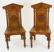 PAIR OF ARCHITECTURAL HALL CHAIRS mid Victorian, having carved cypher medallions to backs - believed