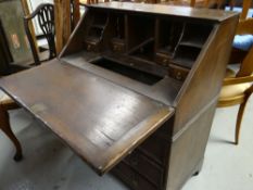 EDWARDIAN OAK BUREAU having fitted three long drawers, fitted interior