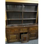 18TH CENTURY WELSH OAK DRESSER with later boarded and reduced rack above a base with three frieze