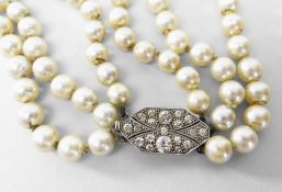 THREE STRAND NECKLACE OF GRADUATED CULTURED PEARLS having an unmarked white metal diamond