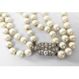 THREE STRAND NECKLACE OF GRADUATED CULTURED PEARLS having an unmarked white metal diamond