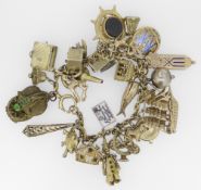 9CT YELLOW GOLD CHARM BRACELET having approximately 30 yellow metal charms of varying design to