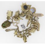 9CT YELLOW GOLD CHARM BRACELET having approximately 30 yellow metal charms of varying design to