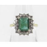 18CT YELLOW GOLD EMERALD & DIAMOND DRESS RING, the central emerald (7 x 9mms) surrounded by