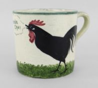 A LLANELLY POTTERY MUG painted with a single black cock crowing on grass with speech bubble from