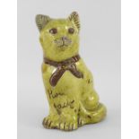 EWENNY POTTERY MODEL OF A SEATED CAT in mottled yellow glaze, unglazed bow and eyes, incised