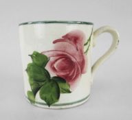 A LLANELLY POTTERY MUG painted with single tea-rose on branch with leaves, stencilled Llanelly to