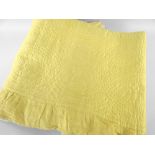 ANTIQUE WELSH QUILT in daffodil yellow, spiral design with larger centred motif, border skirt,