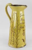 EWENNY POTTERY SLIPWARE WATER JUG of tapered form with loop handle, in mustard glaze, naturalistic