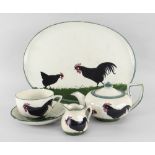 A LLANELLY POTTERY FOUR PIECE CABARET TEA SET painted with Black Cocks strutting on grass,
