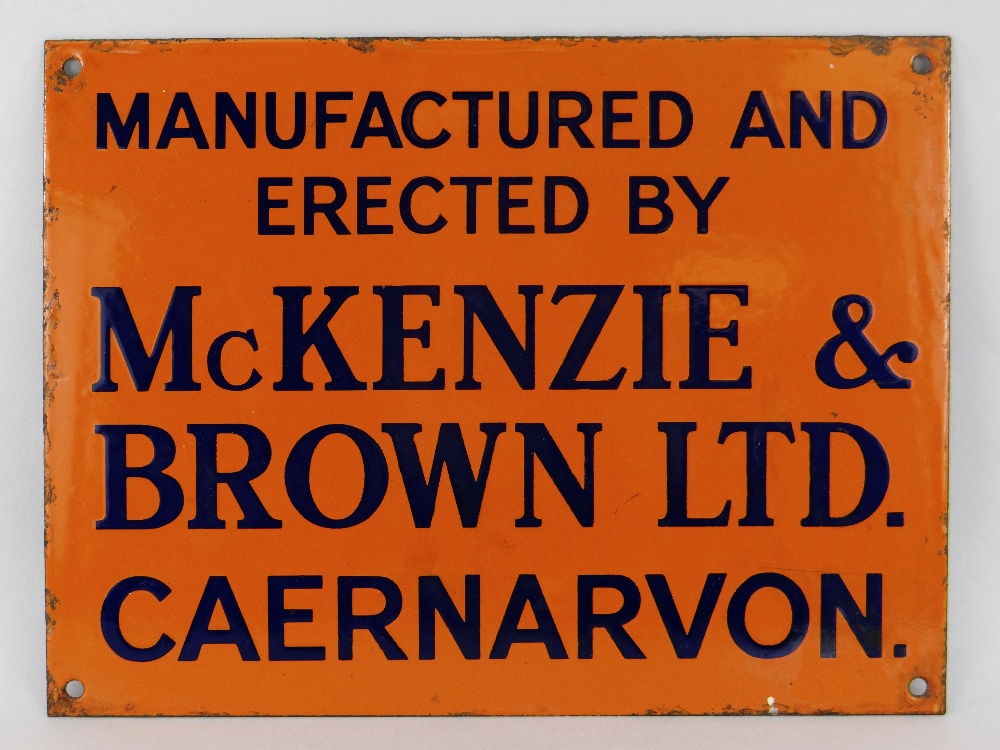 ENAMEL SIGN FOR MCKENZIE & BROWN LTD CAERNARVON orange ground with blue lettering, 23 x 31cms