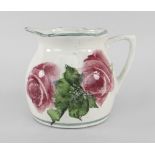 A LLANELLY POTTERY MILK JUG painted with tea-roses and leaves, stencilled Llanelly to base, 8cms