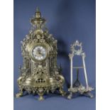 ROCOCO BRASS MANTEL CLOCK and an easel frame, the clock being antique style cast in pierced and